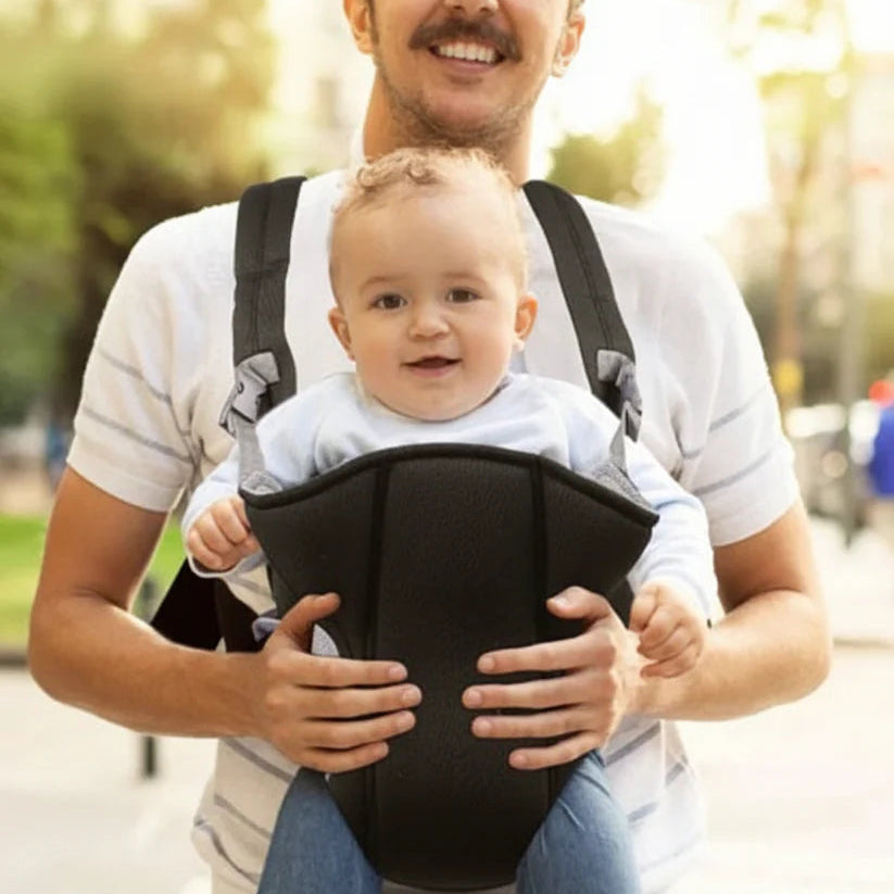 papa portant bébé face à la rue en porte bébé noir